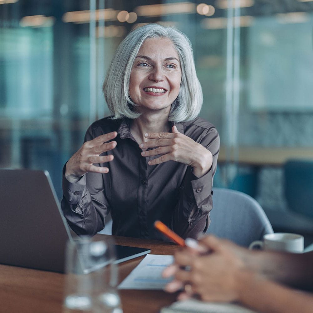 Businesswoman smiling during a professional meeting in an office setting.